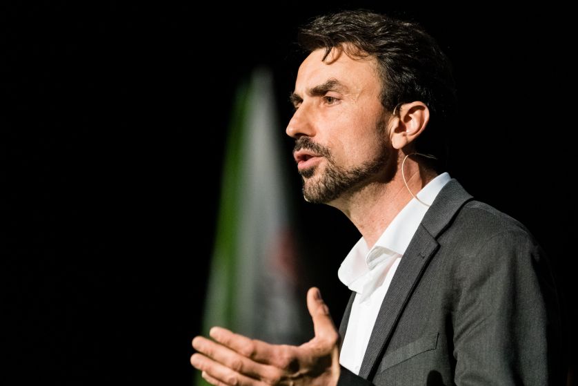 Le candidat Grégory Doucet en pleine campagne dans une salle à Lyon, en train de parler avec ses mains