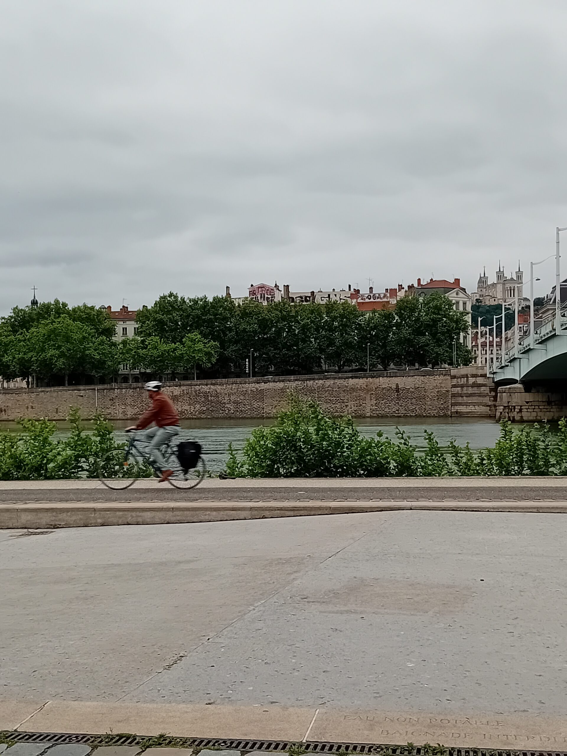 Une dame faisant du vélo sur les quais du Rhône